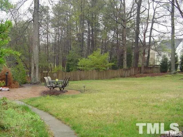 a view of a backyard with table and chairs under an umbrella