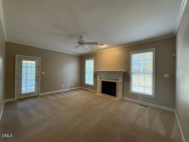 an empty room with windows and fireplace