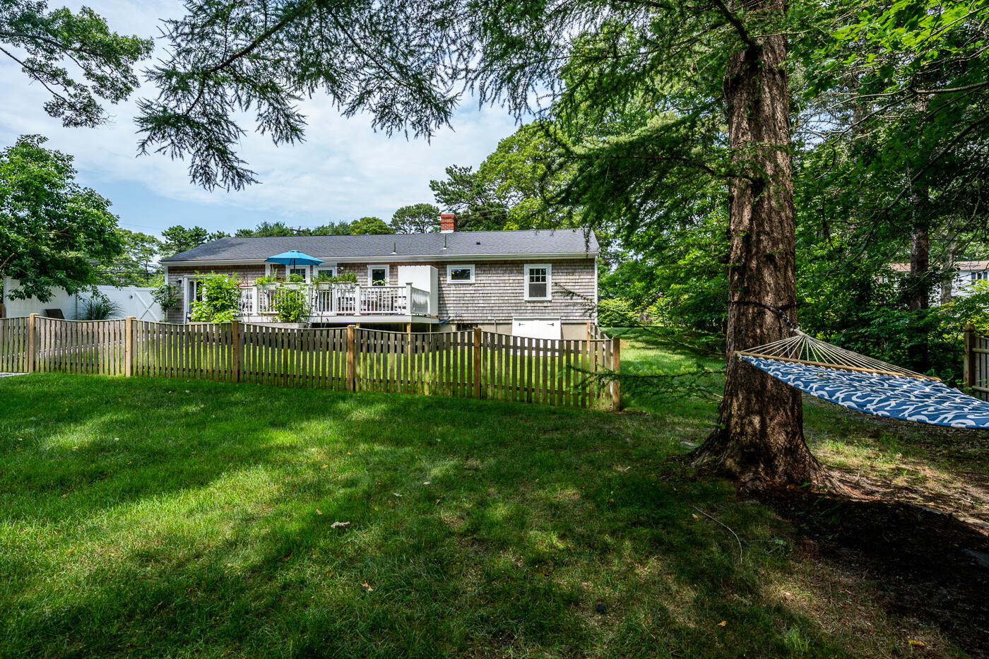 157 Lumbert Mill Road Centerville, MA 02632 - Photo 34 of 42 a view of a house with a yard chairs and a large tree