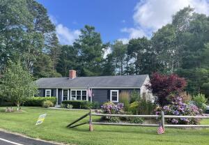 157 Lumbert Mill Road Centerville, MA 02632 - Photo 42 of 42 a front view of a house with a yard table and chairs