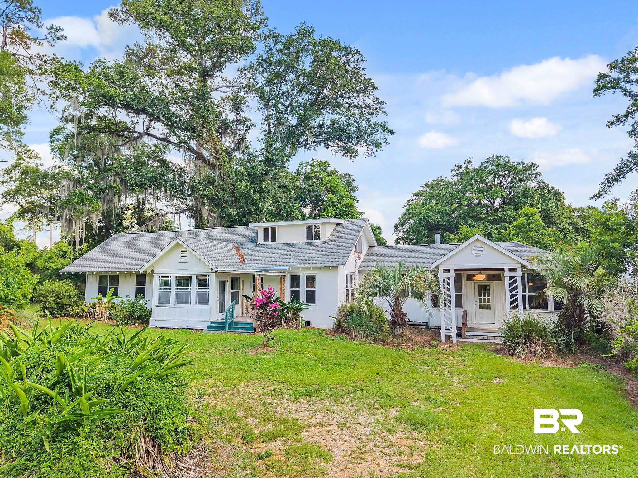 7189 Helton Drive Foley, AL 36535 - Photo 1 of 99 View of front facade with a front lawn, covered porch, and roof with shingles