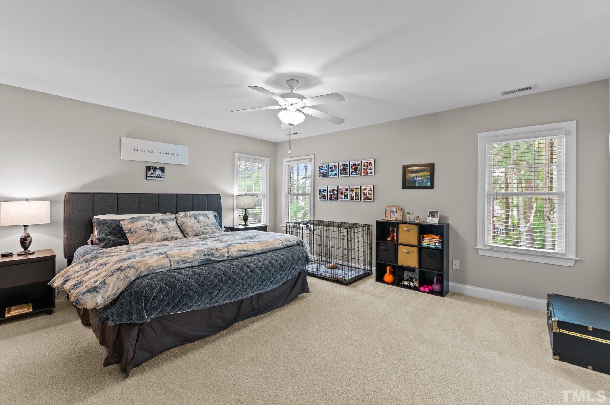 1209 Colonial Club Road Wake Forest, NC 27587 - Photo 16 of 28 a large bedroom with a bed and a chandelier