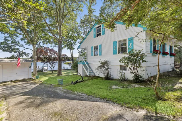 a view of a yard in front of a house with large tree