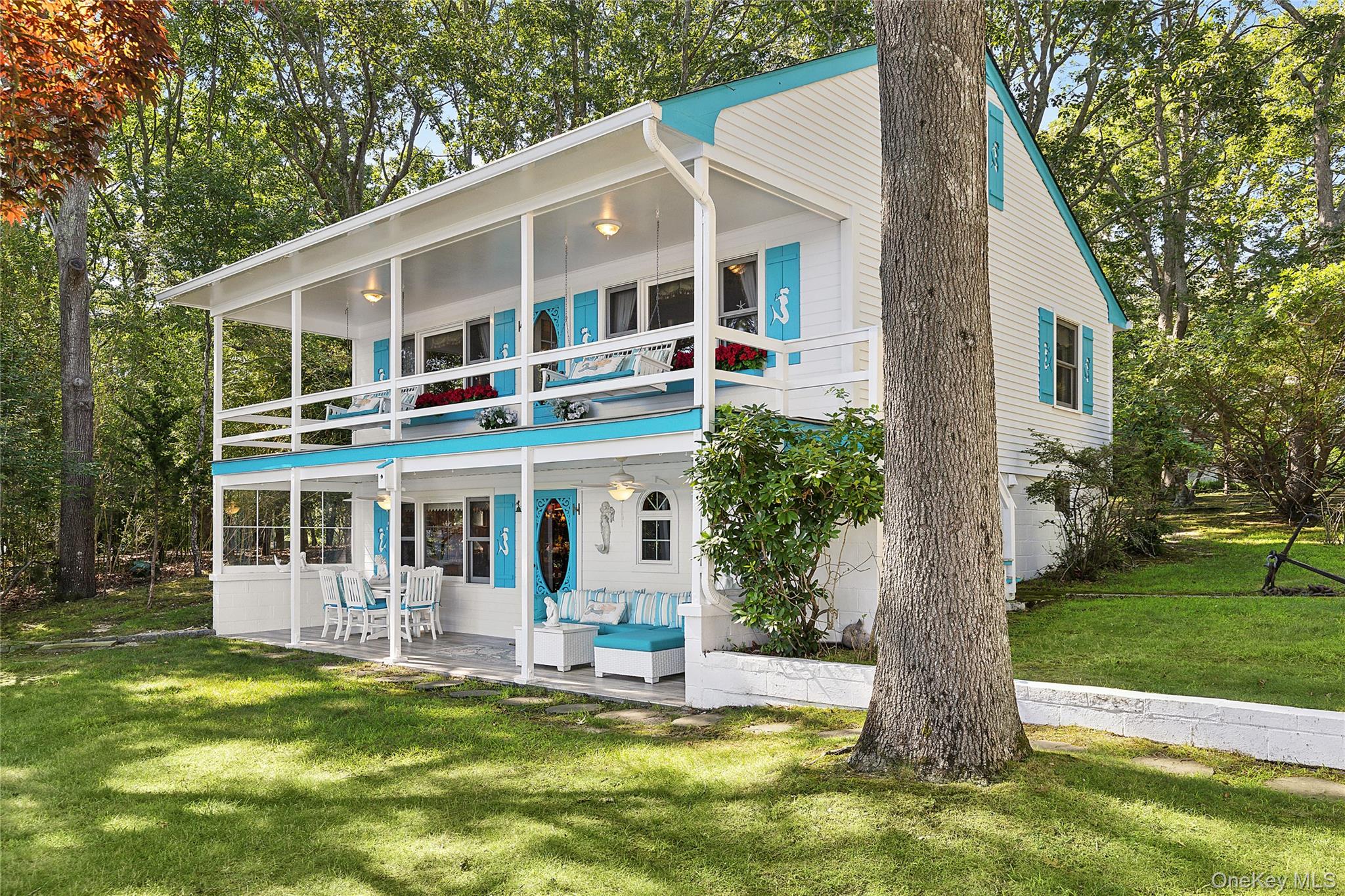 210 Redwood Road Sag Harbor, NY 11963 - Photo 6 of 26 a front view of a house with a yard table and chairs