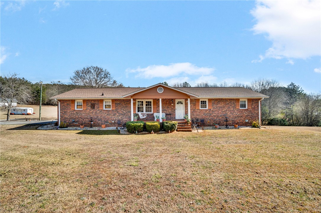 This classic brick ranch home offers a welcoming front porch and mature landscaping.