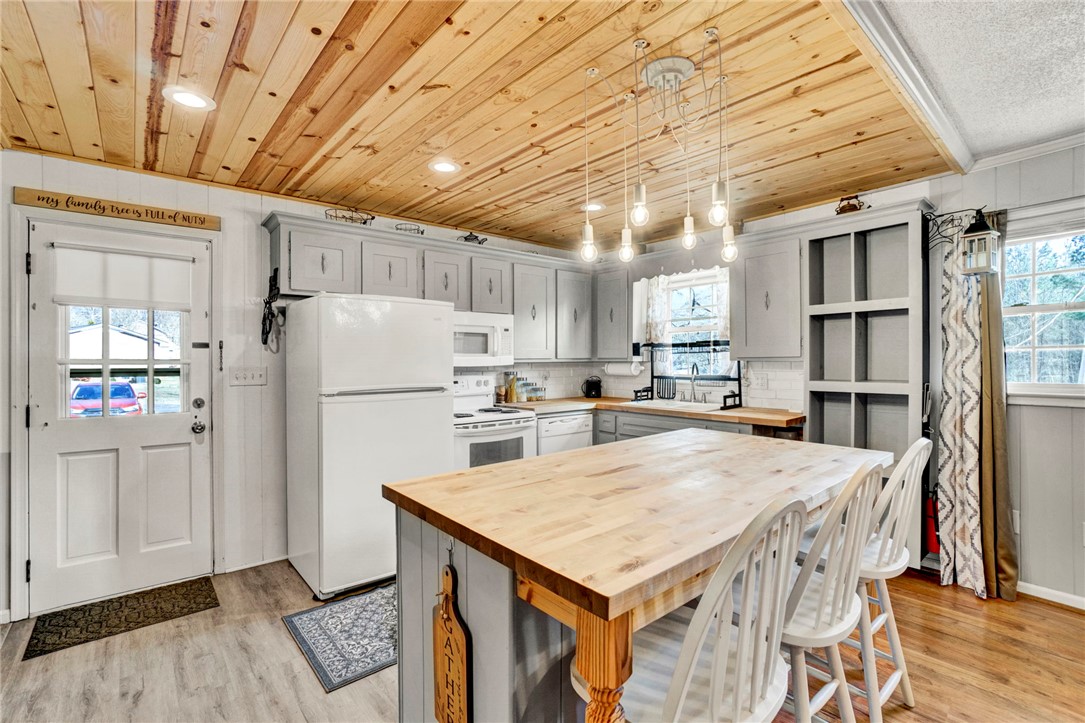 133 Old Liberty Pickens Road Pickens, SC 29671 - Photo 13 of 48 This bright kitchen features a spacious island, white appliances, and a unique wood-paneled ceiling.