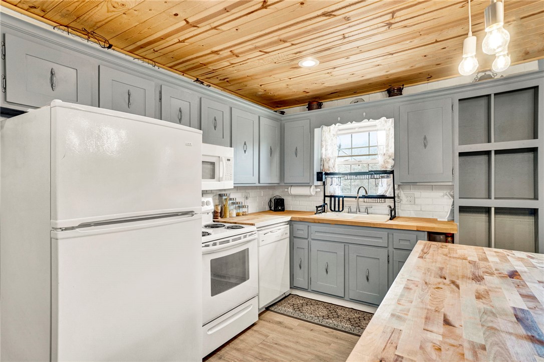133 Old Liberty Pickens Road Pickens, SC 29671 - Photo 15 of 48 This bright kitchen features wood flooring and a classic wooden ceiling, offering a cozy and inviting atmosphere.