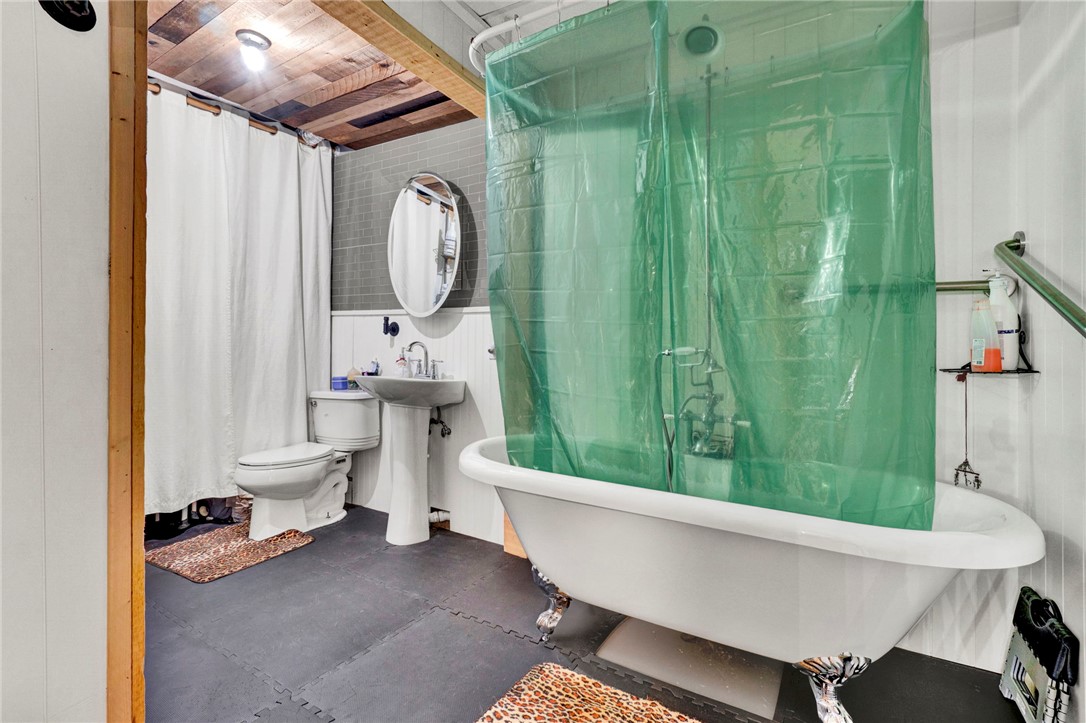 133 Old Liberty Pickens Road Pickens, SC 29671 - Photo 41 of 48 This bathroom features a classic clawfoot tub, pedestal sink, and textured wood ceiling.