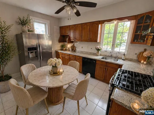 a kitchen with stainless steel appliances granite countertop a stove a sink dishwasher a dining table and chairs with wooden floor