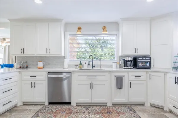 a kitchen with stainless steel appliances granite countertop a sink a stove a cabinets and a window
