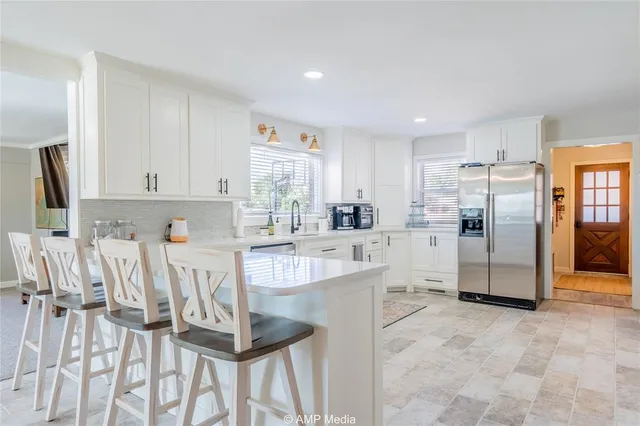 a kitchen with white cabinets and stainless steel appliances
