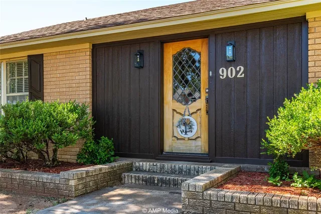 a front view of a house with a door and flower plants