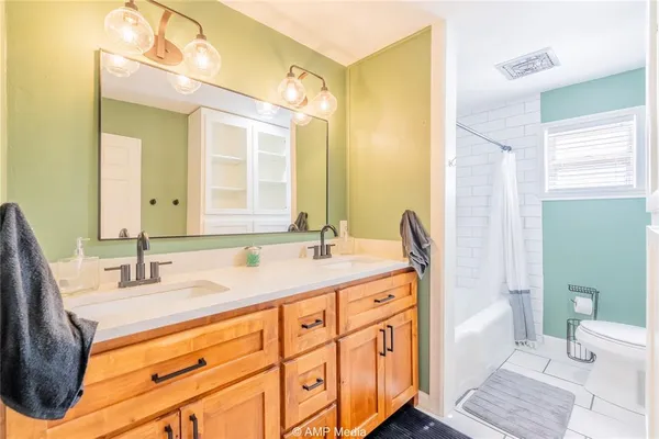 a bathroom with a double vanity sink toilet and a mirror