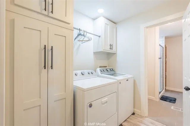 a utility room with cabinets washer and dryer