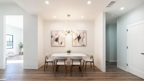 a kitchen with a sink a refrigerator and wooden floor