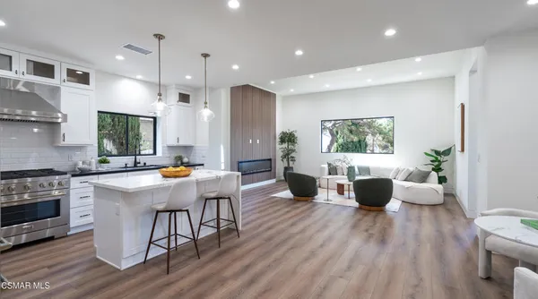 a dining room with furniture a chandelier and wooden floor