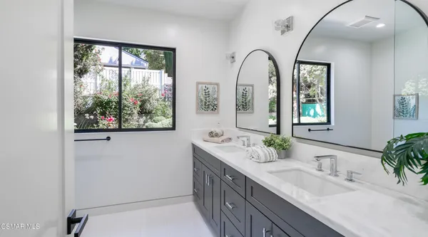 a spacious bedroom with a large bed and a potted plant