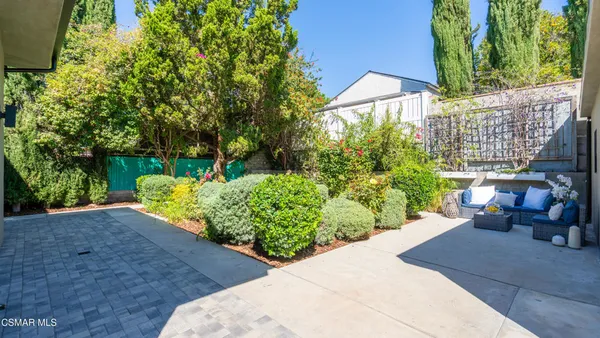 a view of backyard with deck and potted plants