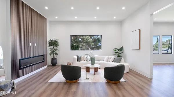 a kitchen with stainless steel appliances a dining table chairs stove refrigerator and cabinets