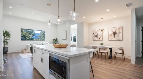 a kitchen that has a lot of cabinets in it and wooden floors