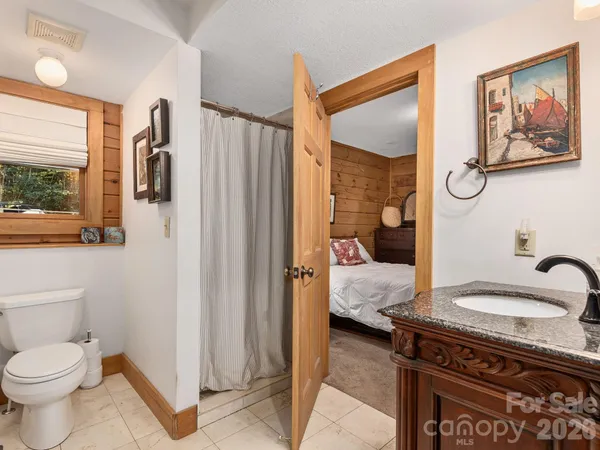 a en suite bathroom with a granite countertop sink and a mirror