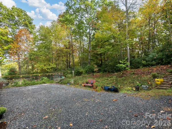 a view of small house with large windows and plants