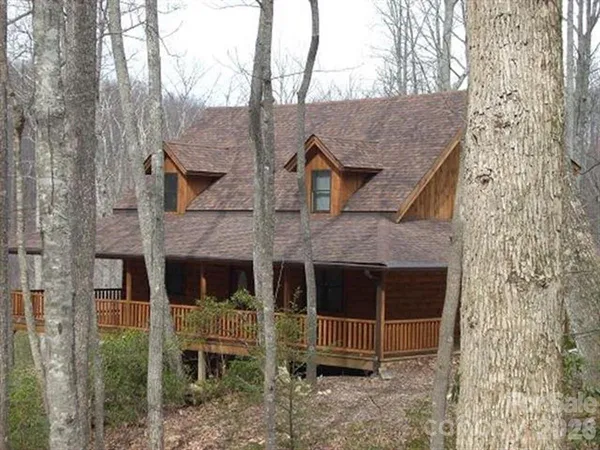 a view of a house with a yard and large tree