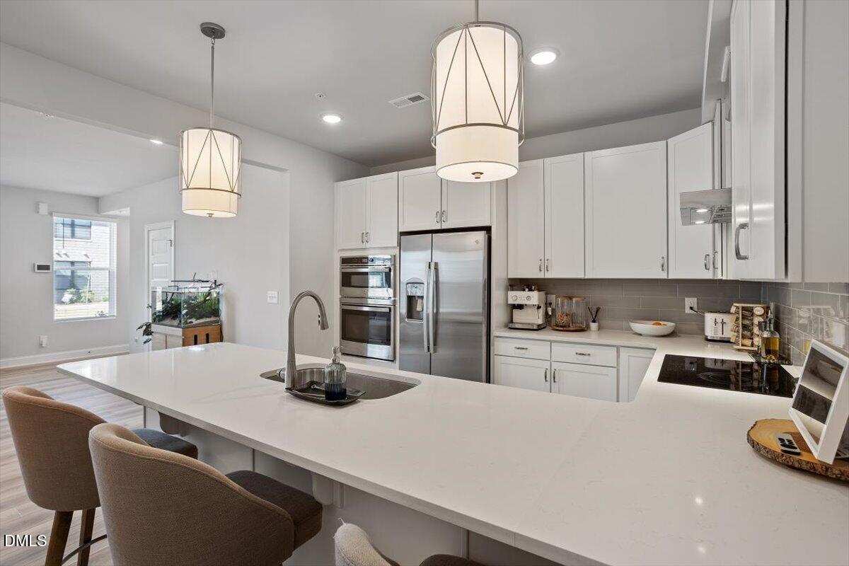 1234 Coach Sta Alley, Unit 101 Raleigh, NC 27601 - Photo 1 of 30 a kitchen with kitchen island granite countertop stainless steel appliances a sink a stove and refrigerator