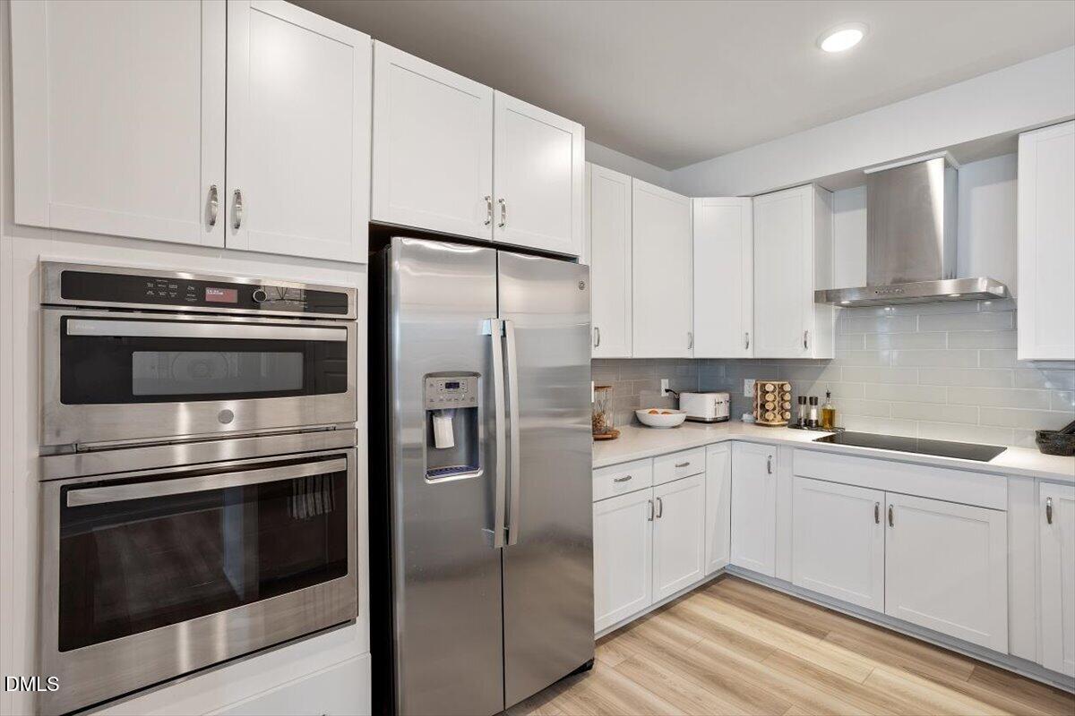 1234 Coach Sta Alley, Unit 101 Raleigh, NC 27601 - Photo 11 of 30 a kitchen with granite countertop white cabinets and stainless steel appliances