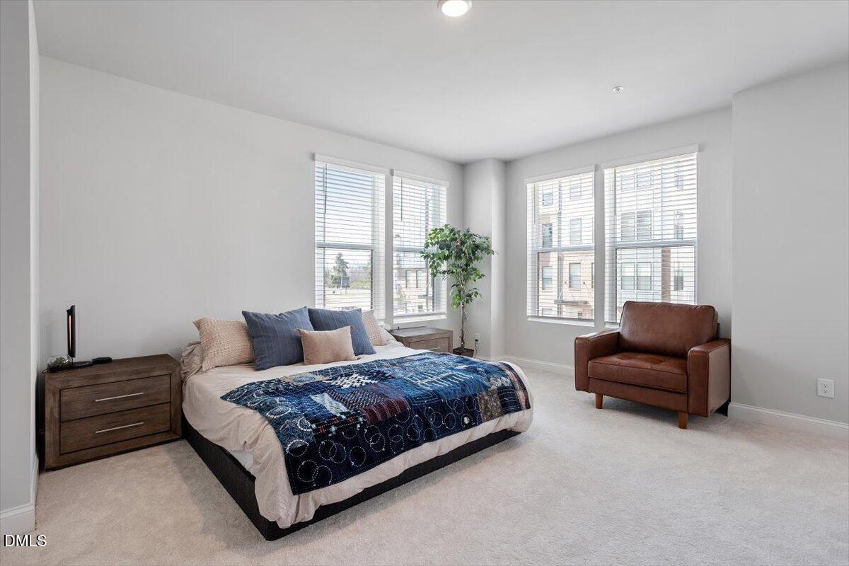 1234 Coach Sta Alley, Unit 101 Raleigh, NC 27601 - Photo 15 of 30 a bedroom with a bed and a couch next to a window