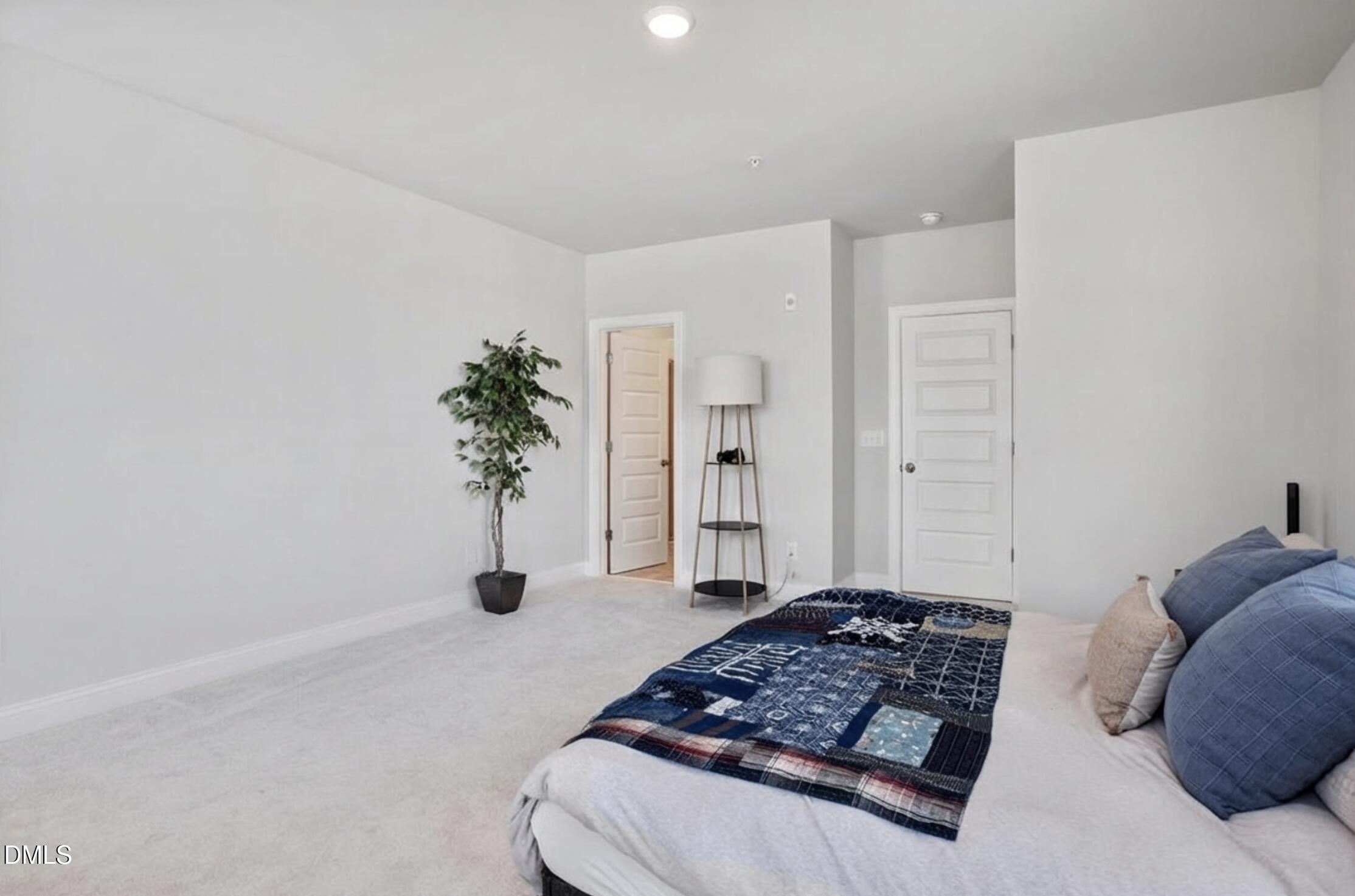 1234 Coach Sta Alley, Unit 101 Raleigh, NC 27601 - Photo 17 of 30 a bedroom with a bed and a potted plant