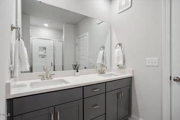 a bathroom with double sink and a mirror