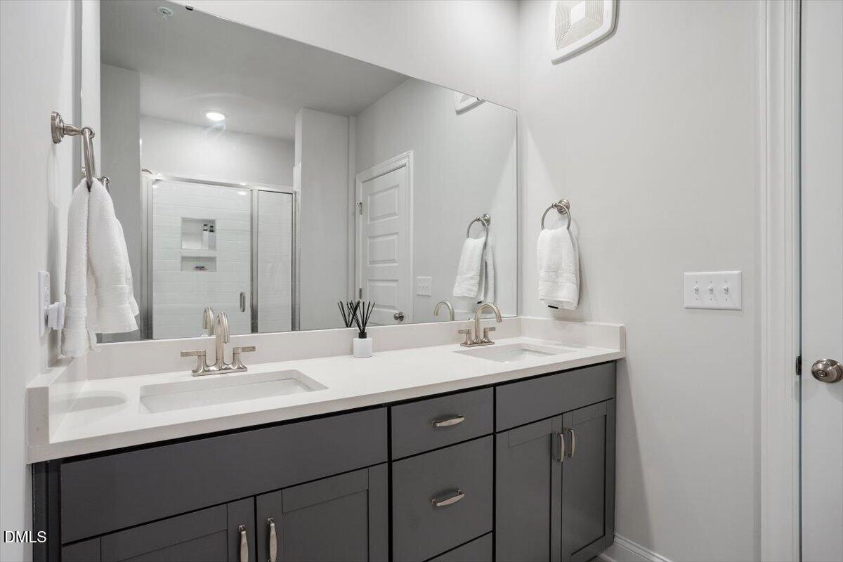 1234 Coach Sta Alley, Unit 101 Raleigh, NC 27601 - Photo 18 of 30 a bathroom with double sink and a mirror