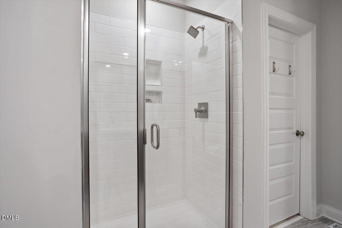 1234 Coach Sta Alley, Unit 101 Raleigh, NC 27601 - Photo 19 of 30 a bathroom with a glass shower door