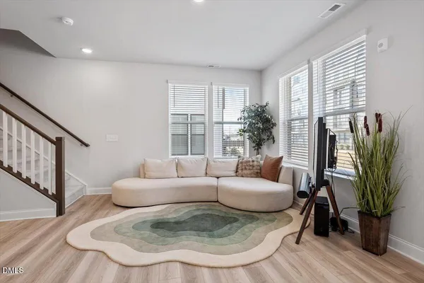 a living room with furniture a potted plant and a large window