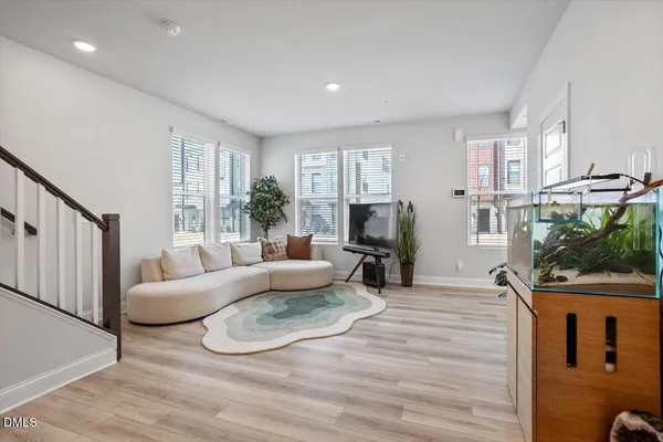 a living room with furniture a large window and a wooden floor