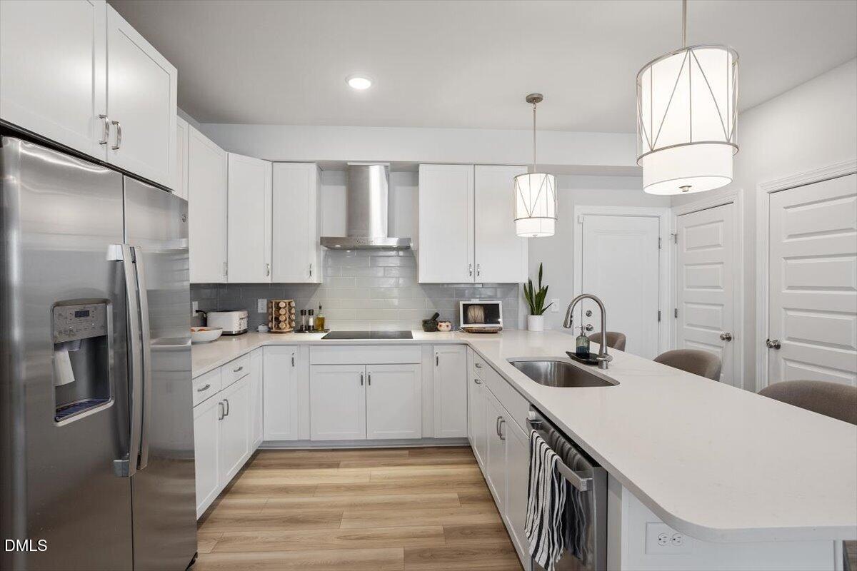 1234 Coach Sta Alley, Unit 101 Raleigh, NC 27601 - Photo 8 of 30 a kitchen with a sink a refrigerator and cabinets