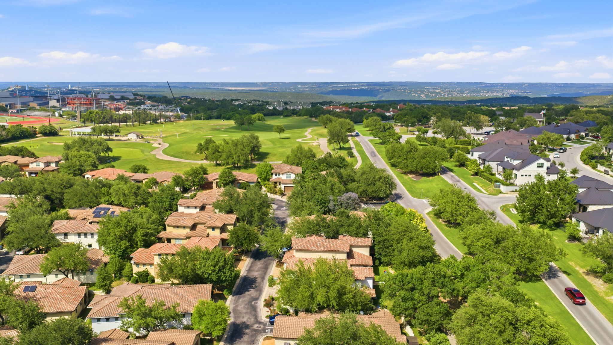 15317 Falconhead Grove Loop Austin, TX 78738 - Photo 29 of 36 Expansive residential community featuring mature trees, a golf course, and a distant stadium