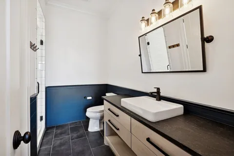a view of a hallway with toilet and wooden floor