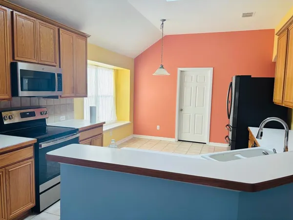 a kitchen with stainless steel appliances a sink a stove and a refrigerator