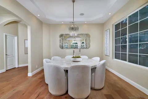 a dining room with stainless steel appliances kitchen island granite countertop a dining table chairs and a refrigerator