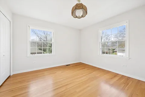 a view of a room with wooden floor and windows