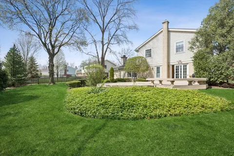 a view of a house with backyard and a tree