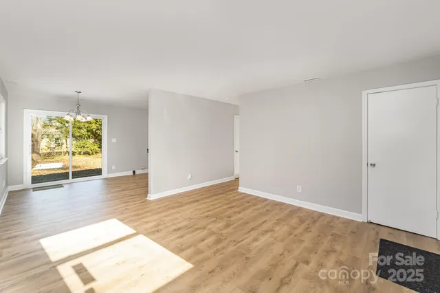 an empty room with window and wooden floor