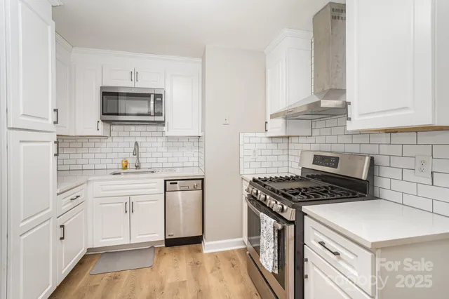 a kitchen with white cabinets stainless steel appliances and sink