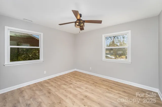 a view of empty room with window and ceiling fan