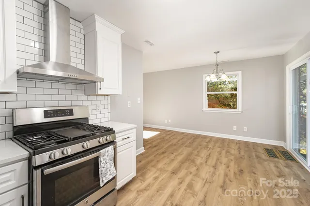 a kitchen with a stove and a wooden floor