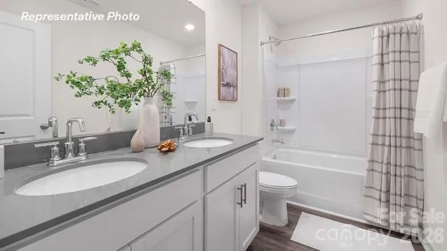 a bathroom with a granite countertop sink a toilet and shower