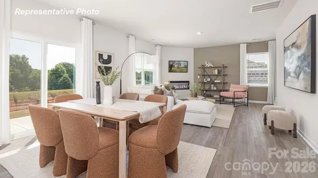 a living room with furniture a large window and wooden floor