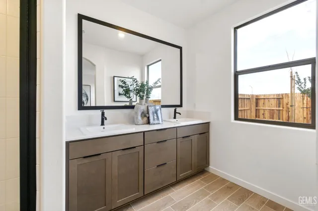a bathroom with a double vanity sink and mirror with window